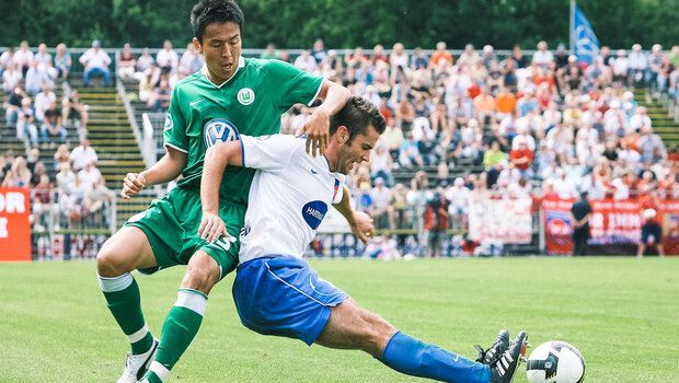 Ehemaliger Spieler des VfL Wolfsburg im Zweikampf mit einem Gegenspieler von Heidenheim.