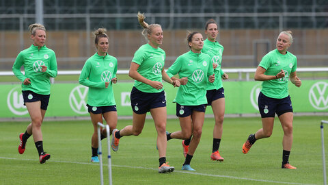 Die Spielerinnen vom VfL Wolfsburg laufen auf dem Trainingsplatz.