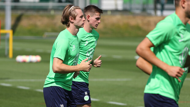 Die VfL Wolfsburg-Spieler Patrick Wimmer und Jakub Kaminski laufen auf dem Trainingsplatz.