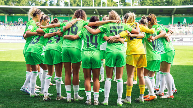 Die Spielerinnen des VfL Wolfsburg stehen in einem Mannschaftskreis.