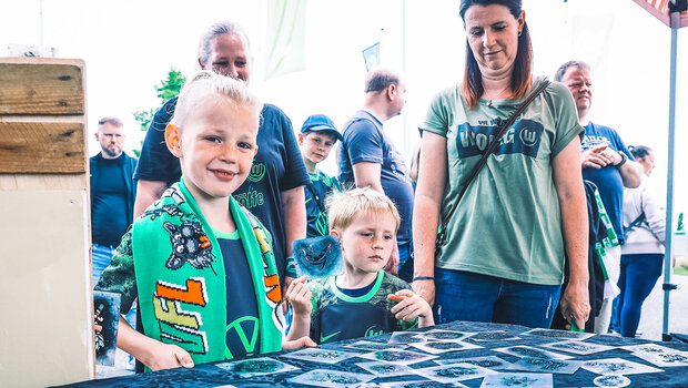 Kleine VfL Wolfsburg Fans stehen beim Familienspieltag an der Volkswagen Arena für Airbrush Tattoos an.