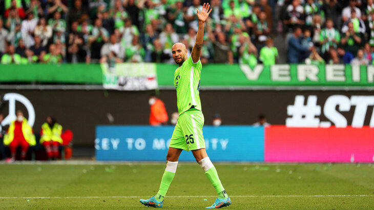 VfL-Wolfsburg-Spieler John Brooks geht über den Platz und winkt den ZUschauern zu.