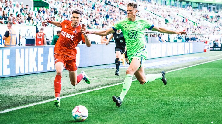 VfL-Wolfsburg-Spieler Micky van de Ven im Laufduell mit einem Kölner Gegenspieler.