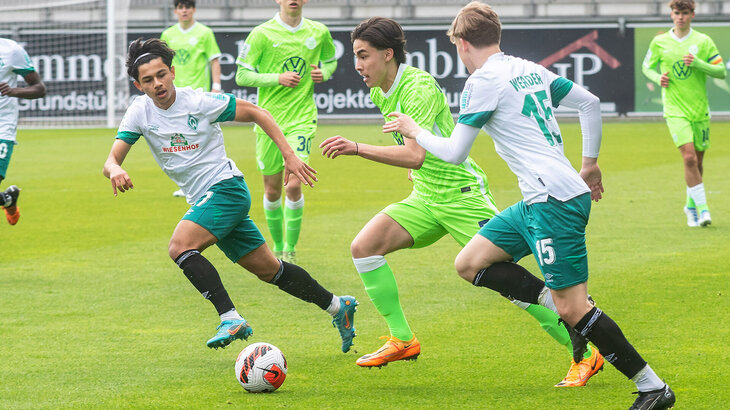 Wolfsburgs U19-Spieler versucht mit dem Ball an den Werder Bremen Spielern vorbeizukommen.
