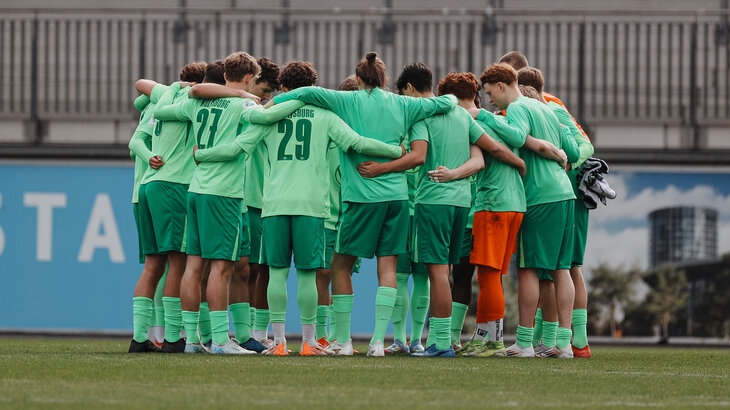 Die Spieler der U17-Mannschaft des VfL Wolfsburg bilden einen Kreis.