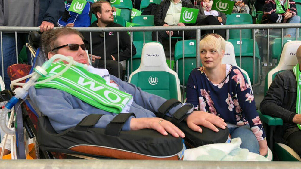 Stefan Moik mit einem Schal des VfL Wolfsburg in der Volkswagen Arena.