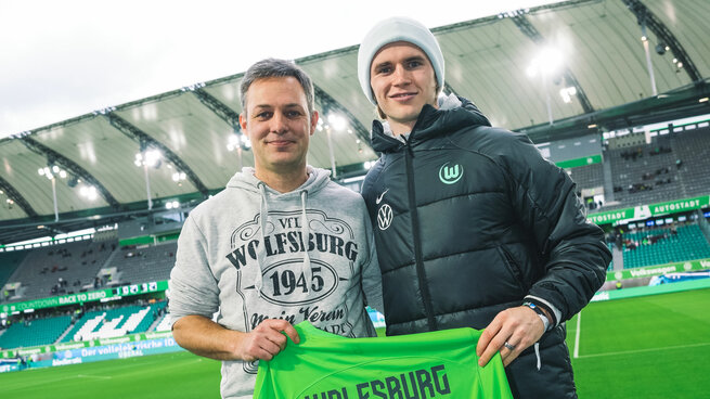Der VfL-Wolfsburg-Fan macht ein Foto mit Spieler Patrick Wimmer.