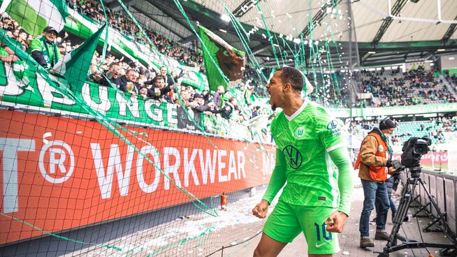 Unser Wolf des Tages Lukas Nmecha steht vor der Nordkurve nachdem er sein 1:0 gegen Bielefeld geschossen hat und brüllt seine überschwängliche Freude den Fans entgegen. Die Nordkurve jubelt ihm zu.