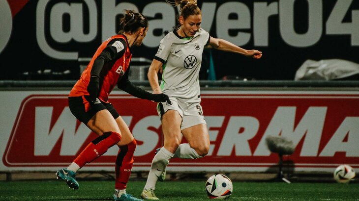 VfL Wolfsburg Spielerin Sarai Linder im Zweikampf mit einer Gegnerin.