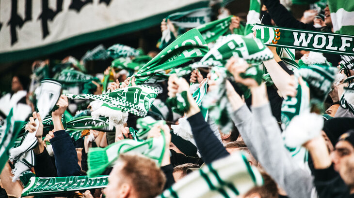 VfL Wolfsburg-Fans wedeln mit ihren Fanschals.