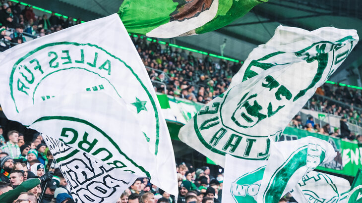 Die Fans des VfL-Wolfsburg schwenken Fahnen ihres Vereins.