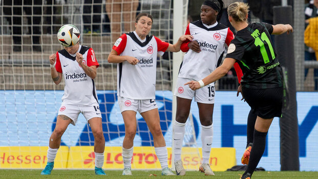 Toschuss von VfL-Spielerin Alexandra Popp. Vor dem Tor stehen drei Spielerinnen aus Frankfurt in einer Reihe. 