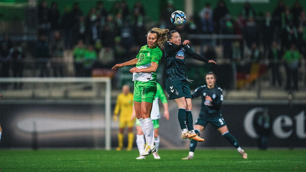 VfL Wolfsburg Spielerin Lattwein im Kopfballduell mit einer Gegnerin aus Bremen.