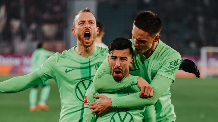 Die VfL-Wolfsburg-Spieler Mohamed Amoura, Maximilian Arnold und Bence Dardai jubeln. 