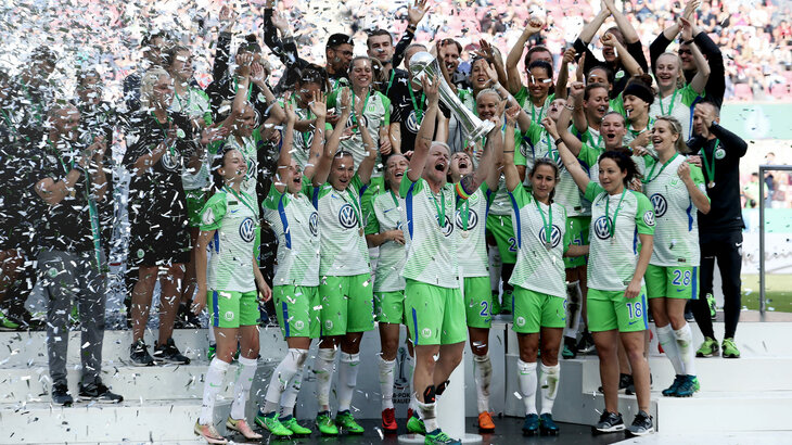 Die VfL Wolfsburg-Frauenmannschaft bei der Siegerehrung mit dem DFB-Pokal. Die Spielerinnen jubeln und es fliegt Konfetti in der Luft.