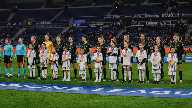 Die Mannschaft der VfL-Wolfsburg-Frauen steht in einer Reihe im Stadion.