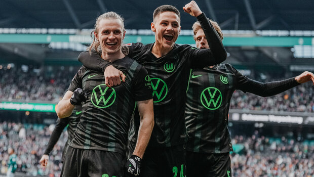 Wolfsburg-Spieler Bence Dardai legt einen Arm um Patrick Wimmer und ballt mit dem anderen eine Faust.