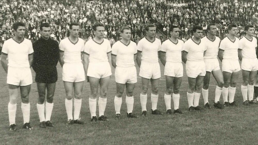 Die Männermannschaft des VfL Wolfsburg aus dem Jahr 1963 steht in weißen Trikots auf dem Spielfeld.