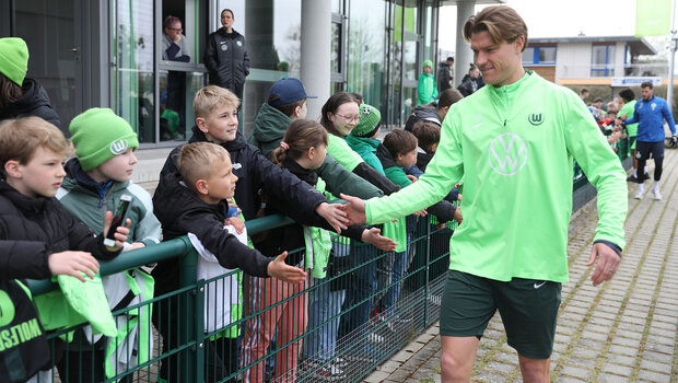 Kevin Behrens klatscht mit wartenden Fans beim Training ab.