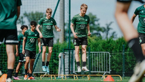 Nachwuchsspieler des VfL Wolfsburg springen im Training über Hindernisse.
