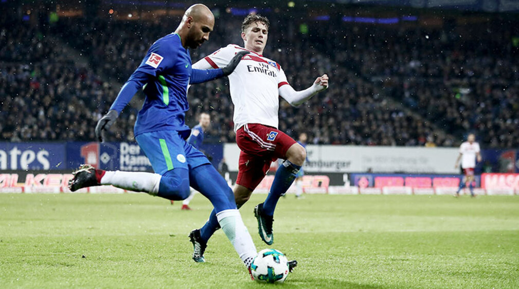VfL Wolfsburg Spieler Brooks erkämpft sich den Ball gegen den Spieler vom HSV. 