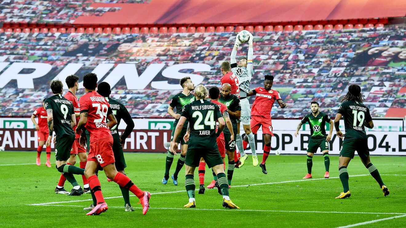 Mitten im Spielergemenge fängt der Torhüter des VfL Wolfsburg in einem Strecksprung den Ball.