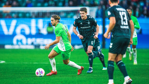 Lovro Majer, Spieler des VfL Wolfsburg, setzt sich im Zweikampf gegen Spieler von Werder Bremen durch.