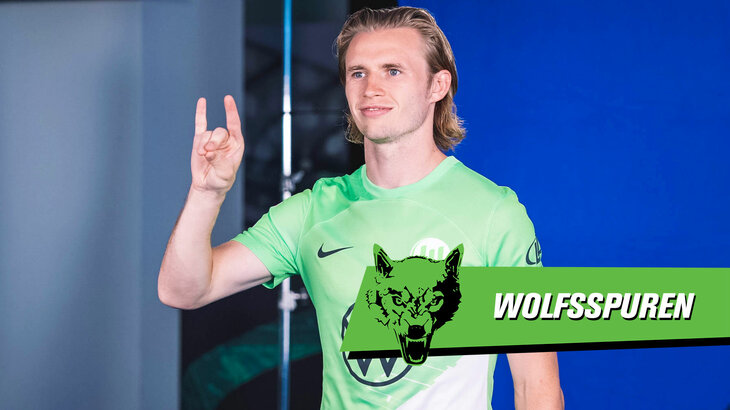 VfL Wolfsburg Spieler Wimmer formt beim Media Day mit der Hand einen Wolfskopf für die Kamera.