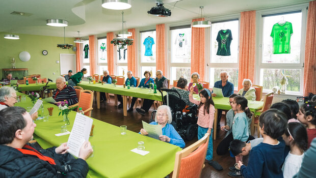 Die Heimbewohner und Heimbewohnerinnen singen gemeinsam mit den Kindern beim Besuch des VfL Wolfsburg.