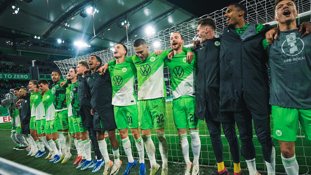 Die Spieler vom VfL Wolfsburg jubeln gemeinsam mit der Nordkurve den Sieg in der 2. Runde des DFB-Pokals gegen RB Leipzig.