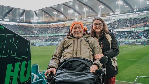 Ein Mann und eine Frau im ALS-Wölfe-Rollstuhl des VfL Wolfsburg.