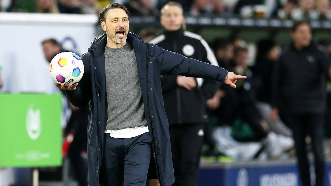 Der VfL-Wolfsburg-Trainer Niko Kovac hält einen Ball in der Hand und gibt Anweisungen.