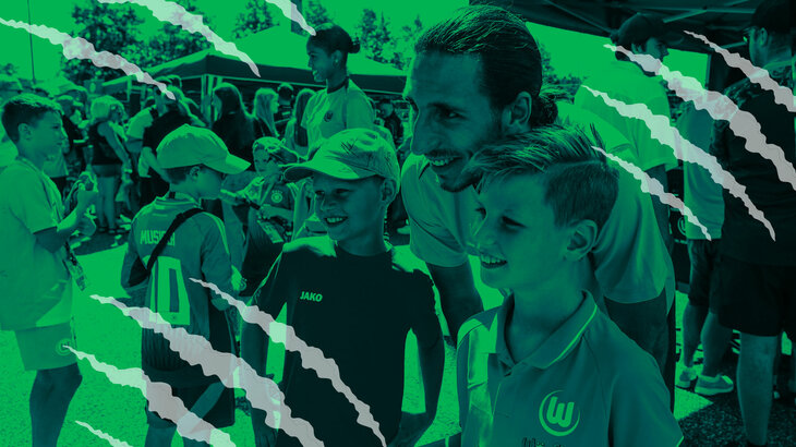 Der VfL-Wolfsburg-Torwart Kamil Grabara posiert für ein Foto mit Fans.