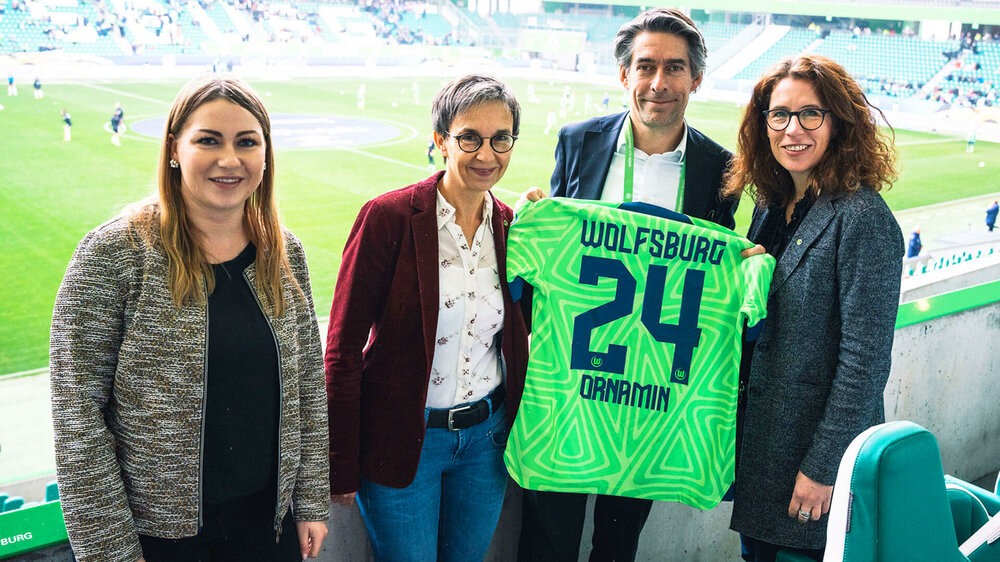 Personen der Firma Ornamin posieren mit VfL-Wolfsburg-Geschäftsführer Michael Meeske als Zeichen einer neuen Partnerschaft.