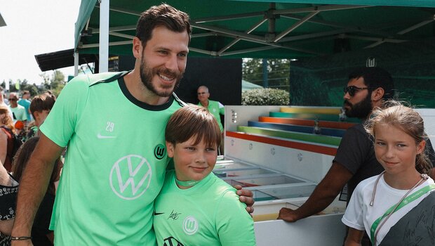 VfL Wolfsburg Torwart Marius Müller posiert beim VfL Familienfest mit einem kleinen Fan für ein Foto.