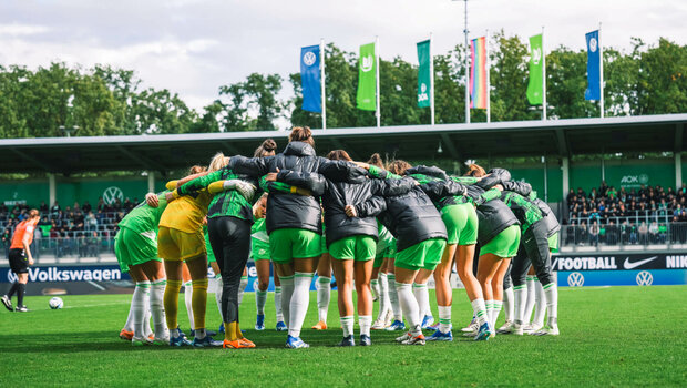 Die VfL-Wolfsburg-Spielerinnen stehen vor dem Spiel im Kreis zusammen.