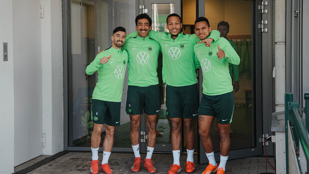 Eine Gruppe von VfL-Wolfsburg-Spielern umarmt sich.