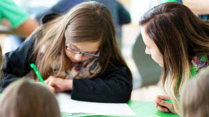 Schreibende Kinder während eines Workshopsim Grün-weißen Klassenzimmer der VfL-FußbalLWelt. 