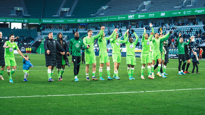 Die Spieler des VfL Wolfsburg jubeln mit den Fans.