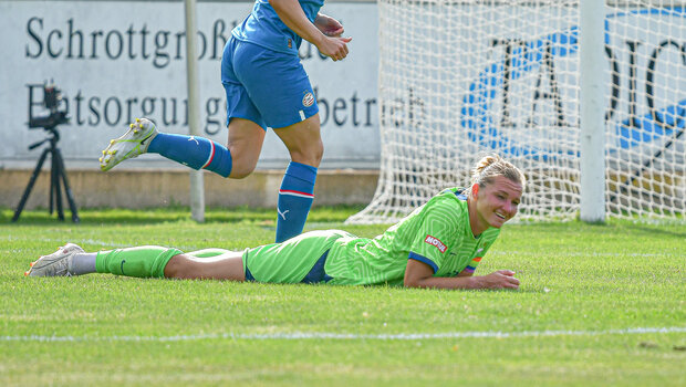 VfL Wolfsburg Stürmerin Alexander Popp liegt lächelnd auf dem Boden.