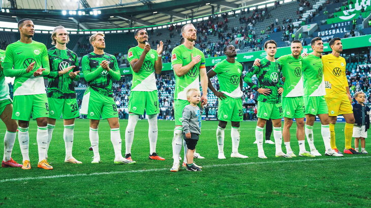 Die Mannschaft des VfL Wolfsburg steht stolz und klatschend vor der Nordkurve.
