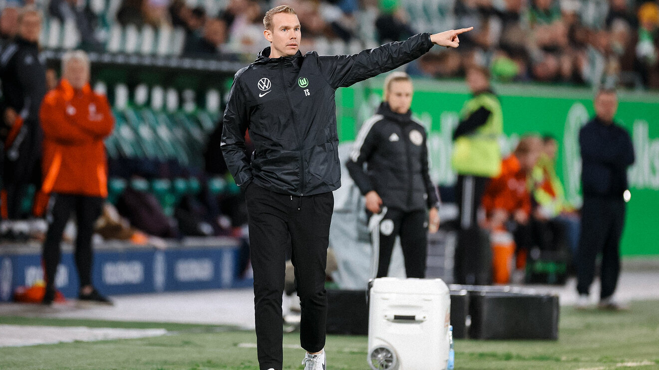 Der Trainer der VfL-Wolfsburg-Frauen Tommi Stroot zeigt nach links.
