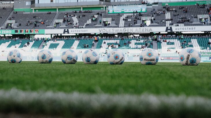 Mehrere Bälle liegen auf dem Rasen in der Volkswagen Arena, der Spielstätte des VfL Wolfsburg.