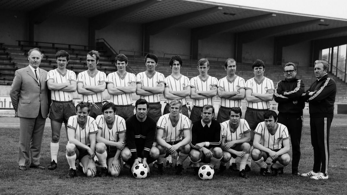Die Herrenmannschaft des VfL Wolfsburg von 1970 stellt sich für ein Mannschaftsfoto auf.