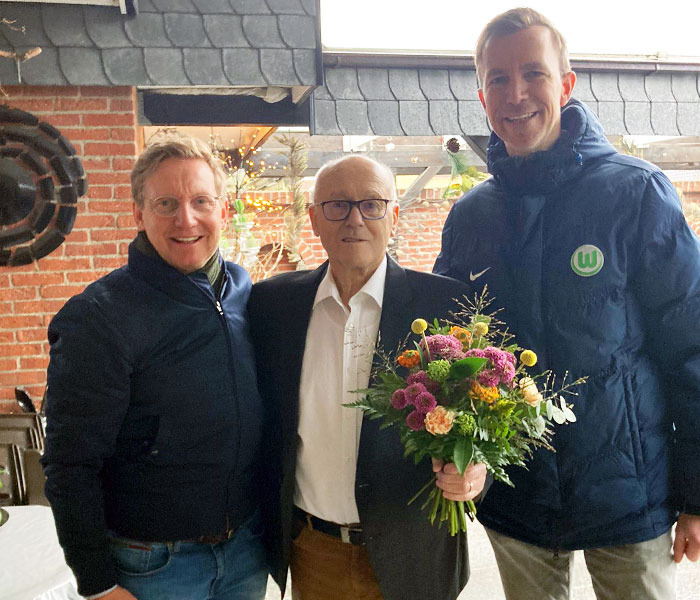 VfL Wolfsburg-Legende Roy Präger und Thomas Franke posieren mit einem 85-jährigen Fan.