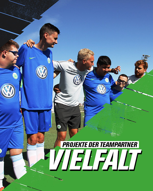 Spieler in blauen Trikots des VfL Wolfsburg bilden einen Kreis. Daneben der Schriftzug Teampartner Vielfalt.