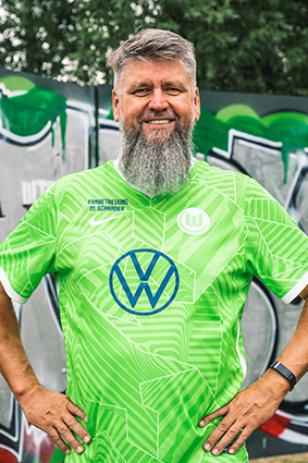 Ein Fanbeauftragter des Vereins im VfL-Wolfsburg-Trikot.