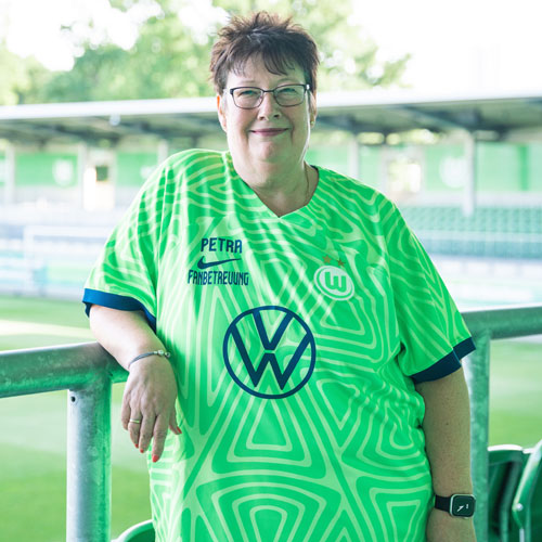 Die Fanbeauftragte Petra steht im VfL Wolfsburg-Trikot im AOK Stadion.