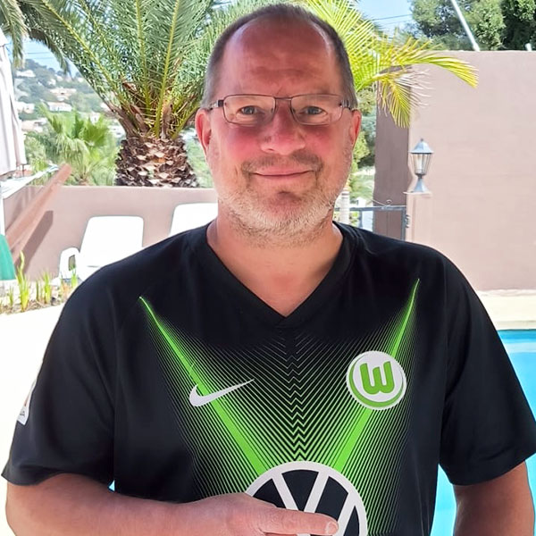 Ein Fan des VfL-Wolfsburg trägt stolz sein Trikot im Urlaub.