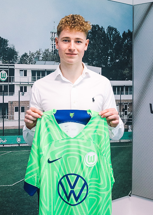 VfL-Wolfsburg-Nachwuchsspieler Max Herrmann hält ein Heimtrikot hoch.